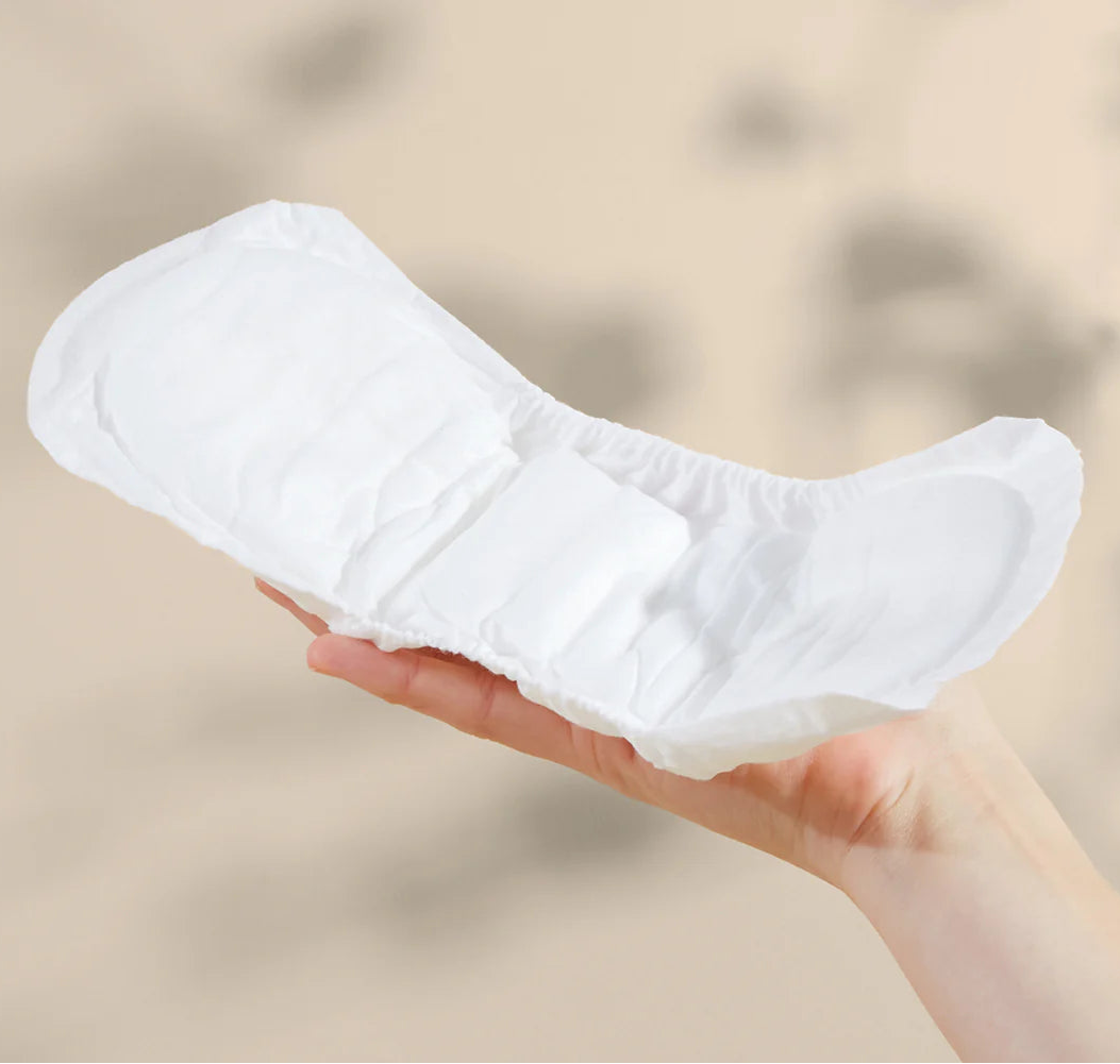 Bare Mum herbal infused postpartum sitting on top of a woman's hand to show the curvature design to fit comfortably while provided sufficient coverage.