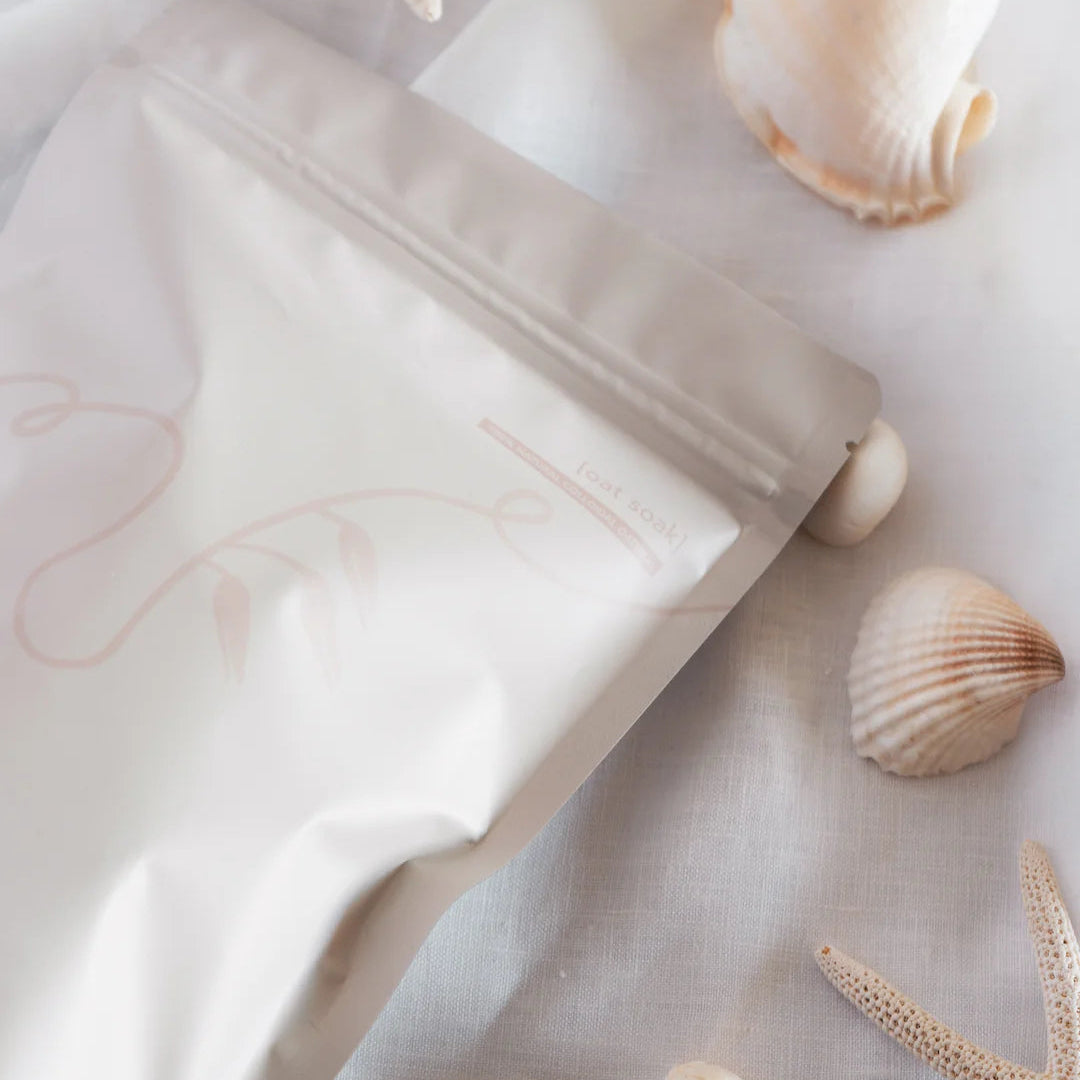 White skincare product with seashells and starfish on a light background
