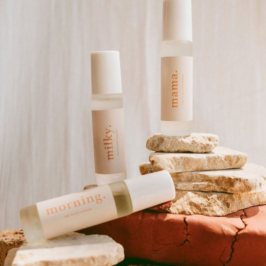 Skincare products labeled 'milky' and 'mama' on a stone surface with a soft background