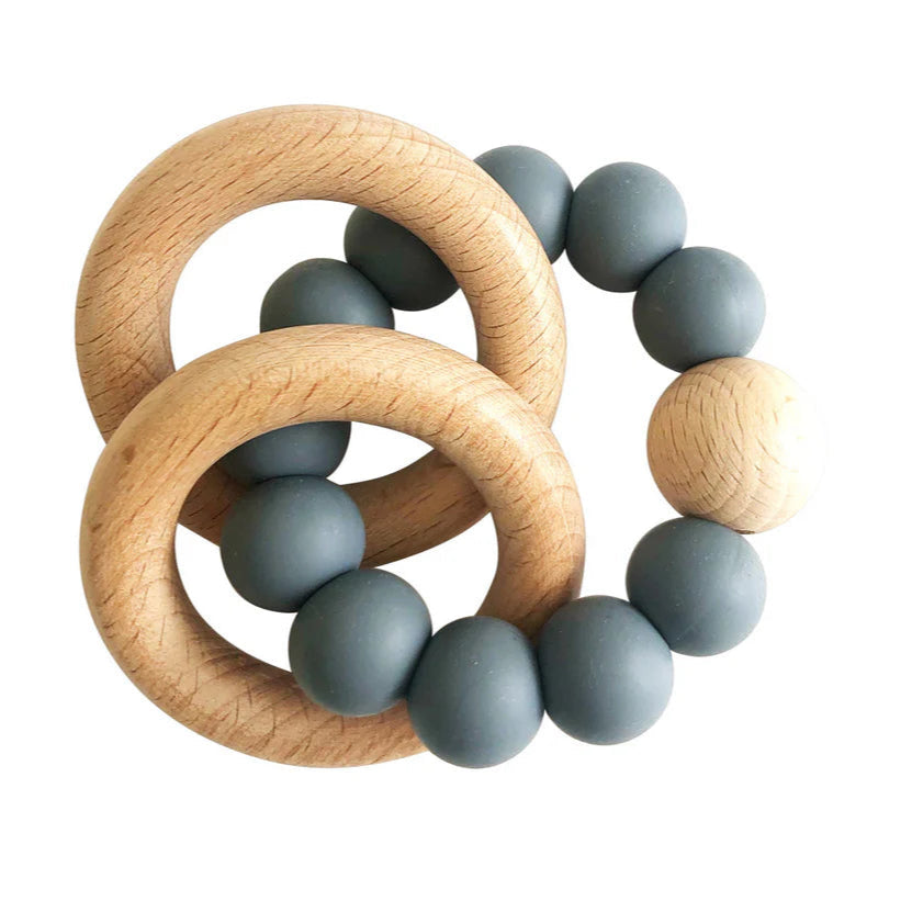 Teething ring with wooden rings and blue silicone beads on a white background
