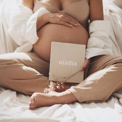 Pregnant person holding a book titled 'mama' with a soft, neutral color palette.