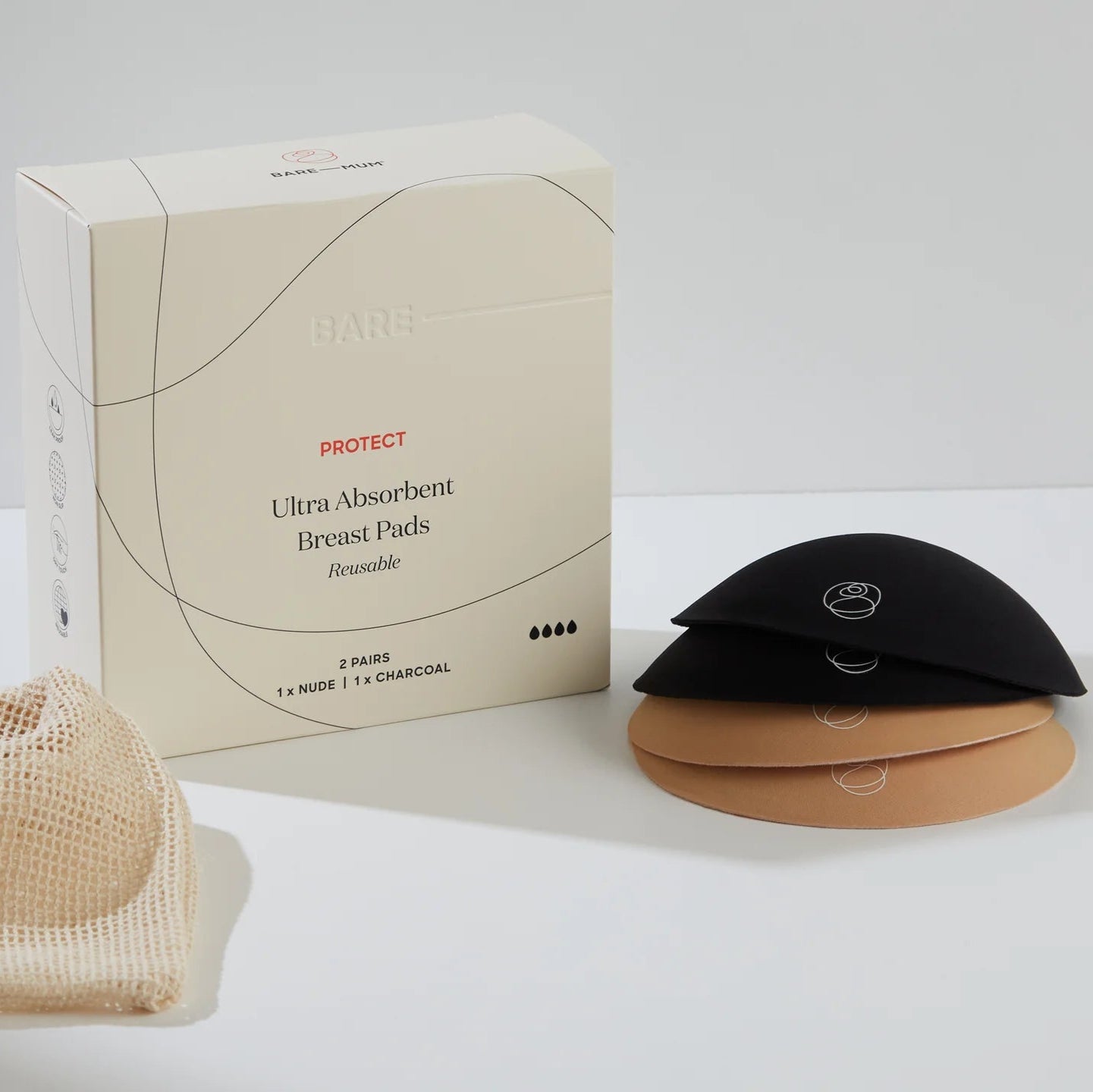 Box of ultra-absorbent breast pads with black and beige pads on a white background