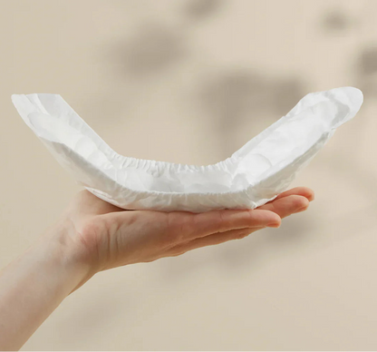 Bare Mum herbal infused postpartum sitting on top of a woman's hand to show the curvature design to fit comfortably.