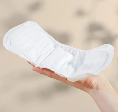 Bare Mum herbal infused postpartum sitting on top of a woman's hand to show the curvature design to fit comfortably while provided sufficient coverage.