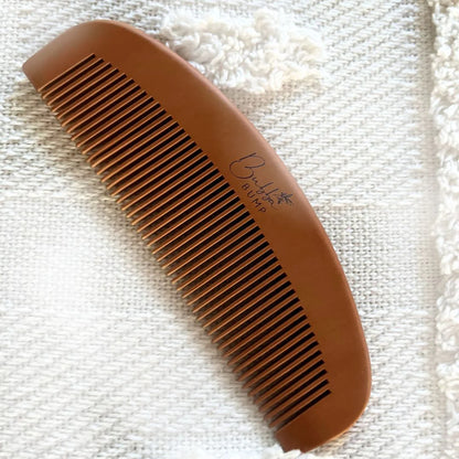Brown birth comb on a white blanket