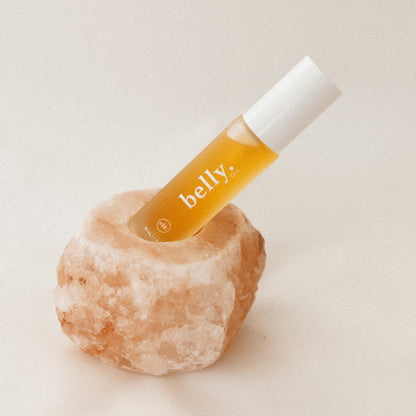 Bottle of 'belly' oil on a salt block with a beige background