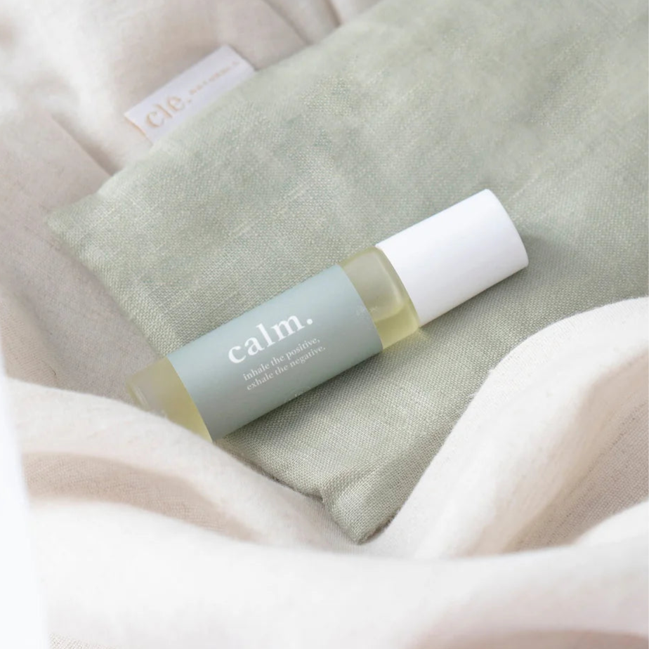 Essentials oil Roller bottle labeled 'calm' on a textured surface