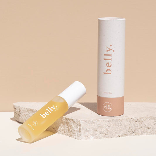 Belly skincare product with applicator and tube on a beige background