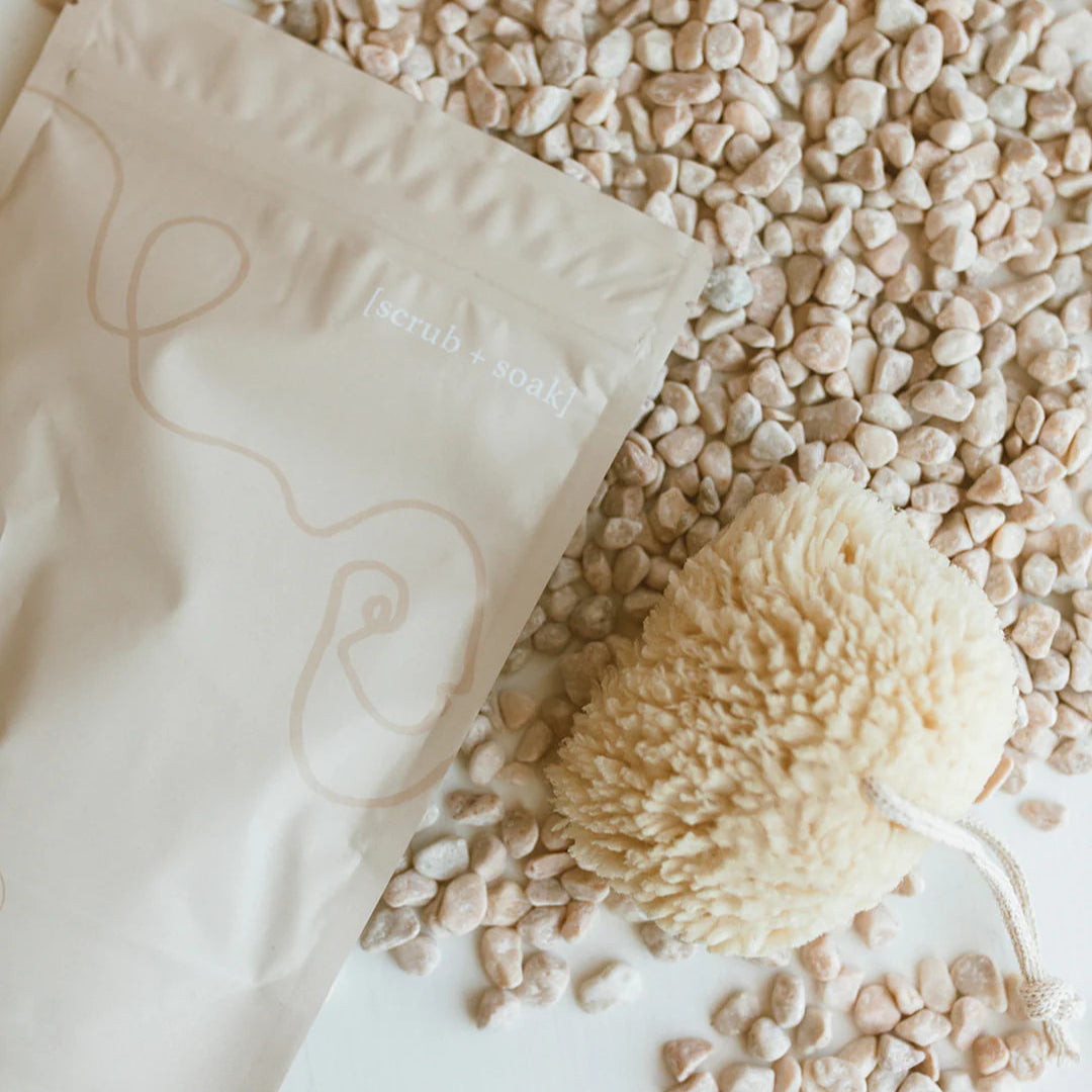 White sponge bar with a decorative design on a white surface with small stones and pebbles.