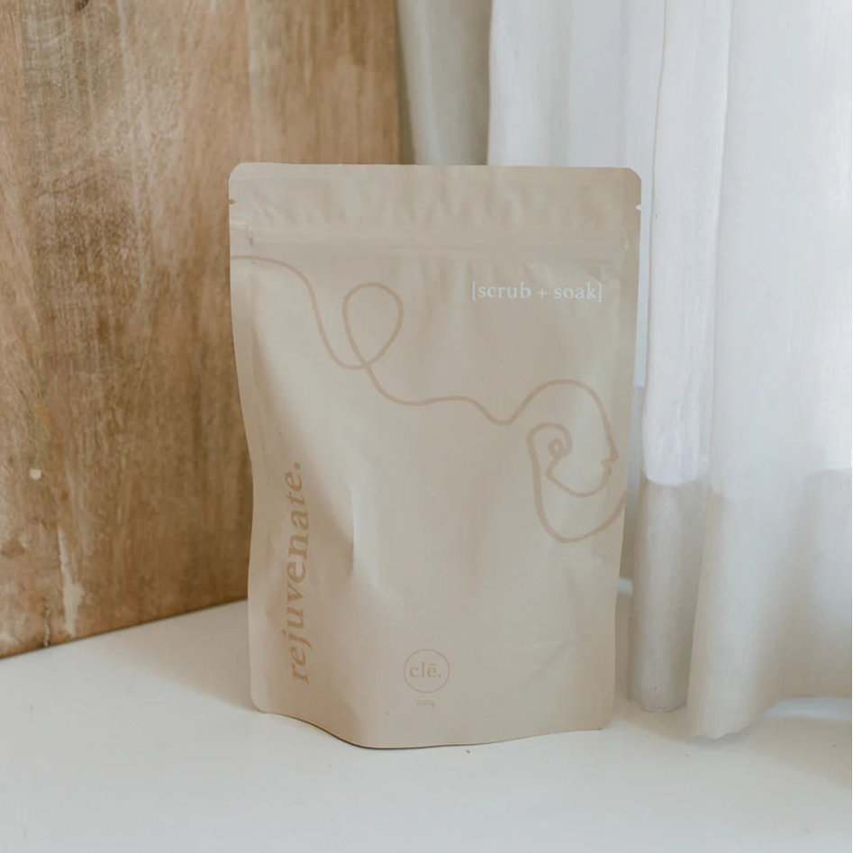 Cle Naturals Rejuvenate bath soak bag with branding on a white surface next to a wooden wall
