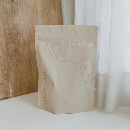 Cle Naturals Rejuvenate bath soak bag with branding on a white surface next to a wooden wall