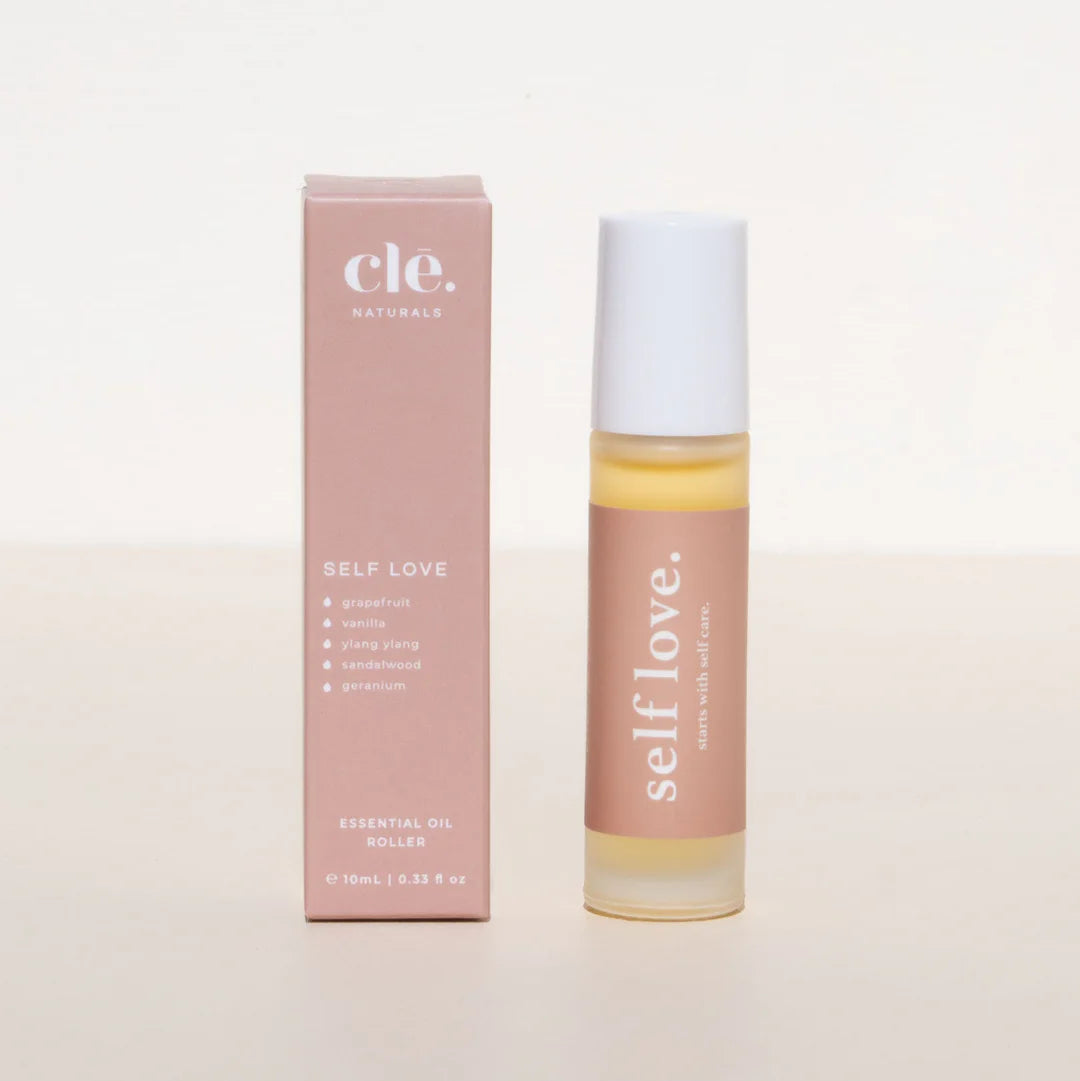 Roll-on bottle and box of 'self love' essential oil on a light background