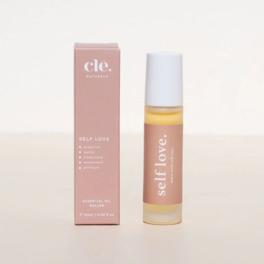 Roll-on bottle and box of 'self love' essential oil on a light background