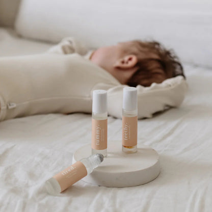 Baby lying on a bed with skincare products in the foreground