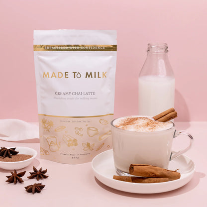 Made to Milk creamy chai latte package with a cup of latte and ingredients on a pink background