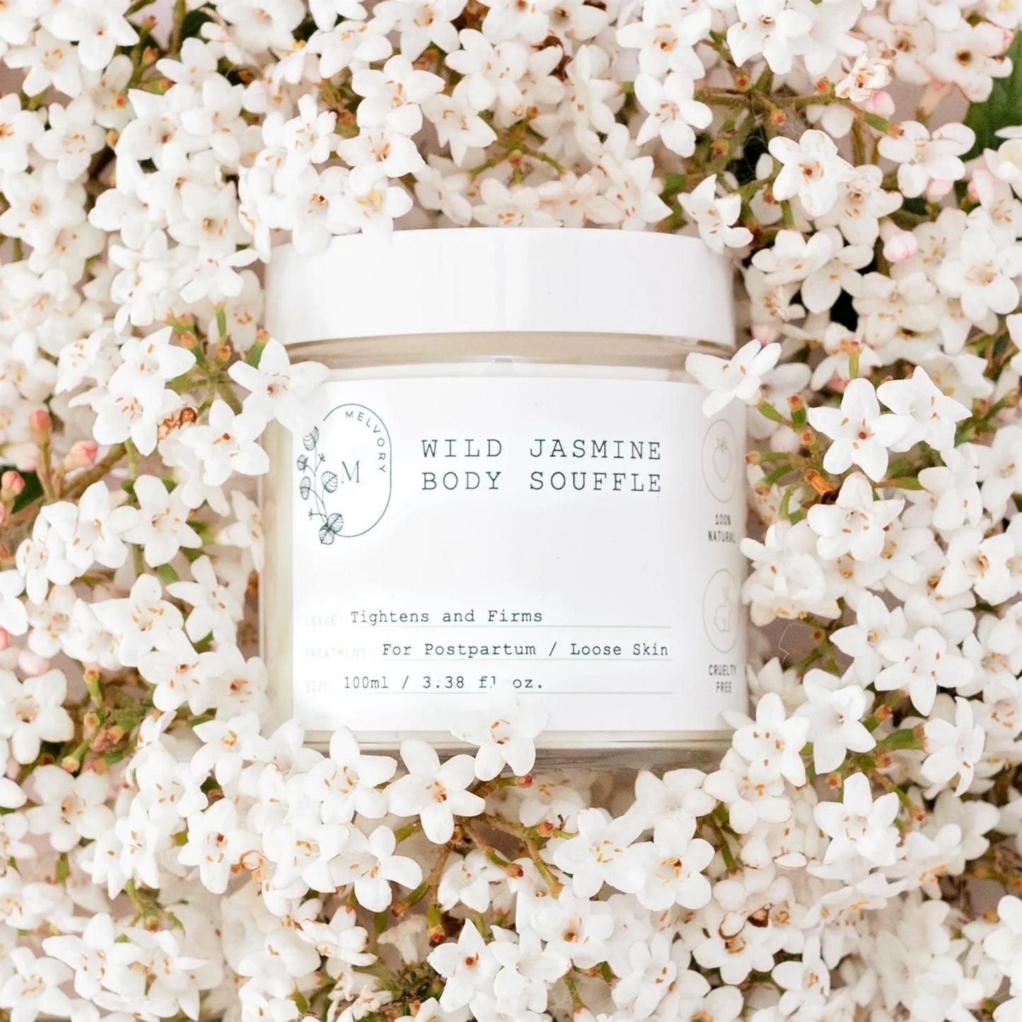 White jar of 'Wild Jasmine Body Souffle' surrounded by white flowers