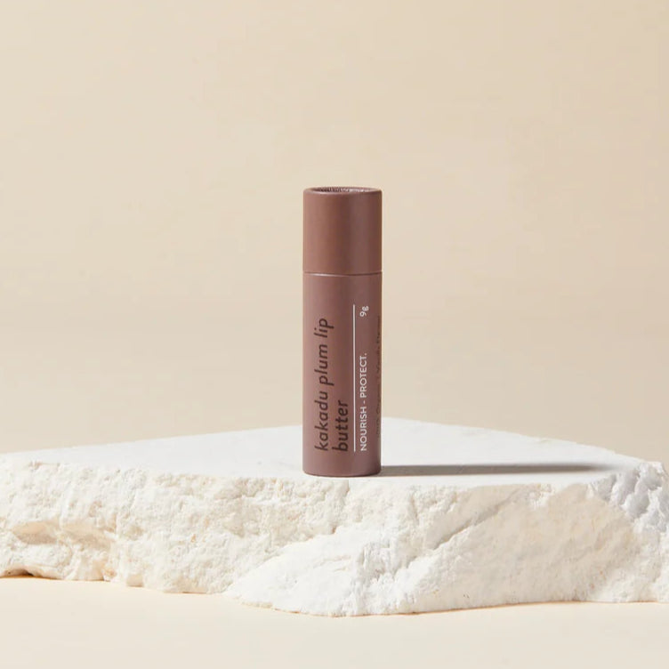 Lip balm on a textured white surface with a beige background