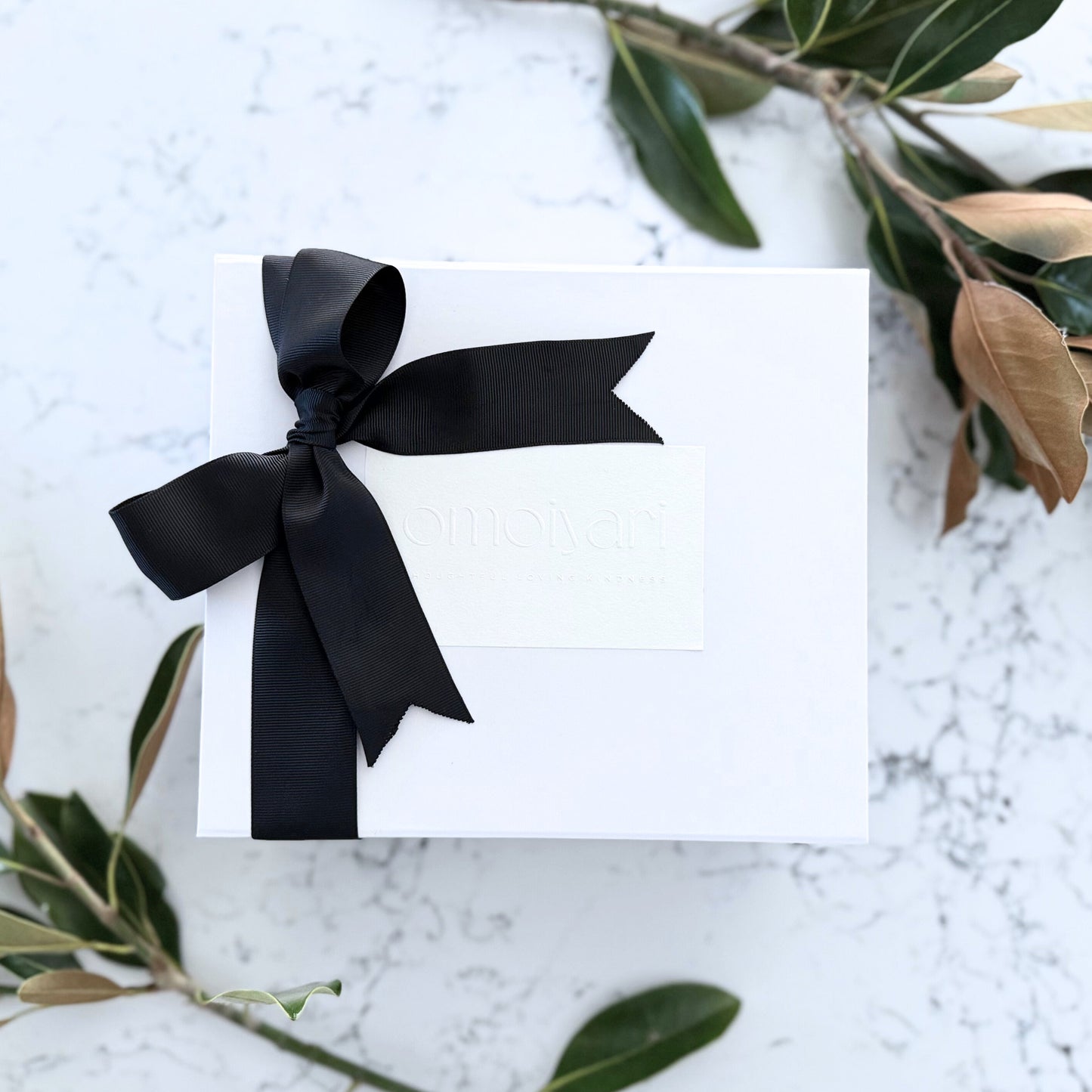 Omoiyari gift hamper box - with an Omoiyari label sticker and black ribbon bow tie
