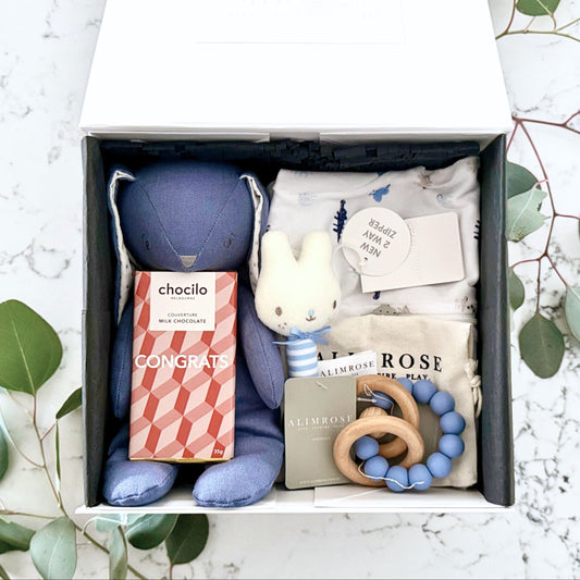 Omoiyari Hello Baby Boy Gift hamper box -  blue bunny plush toy, chocolate, Marquise growsuit, rattle and a teething ring with green gum leaves.