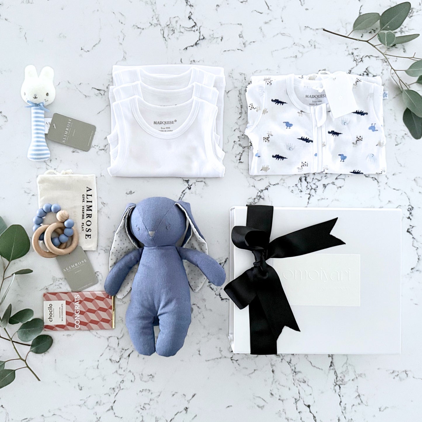 Omoiyari Hello Baby Boy Gift hamper box -  blue bunny plush toy, chocolate, Marquise growsuit, rattle and a teething ring with green gum leaves.