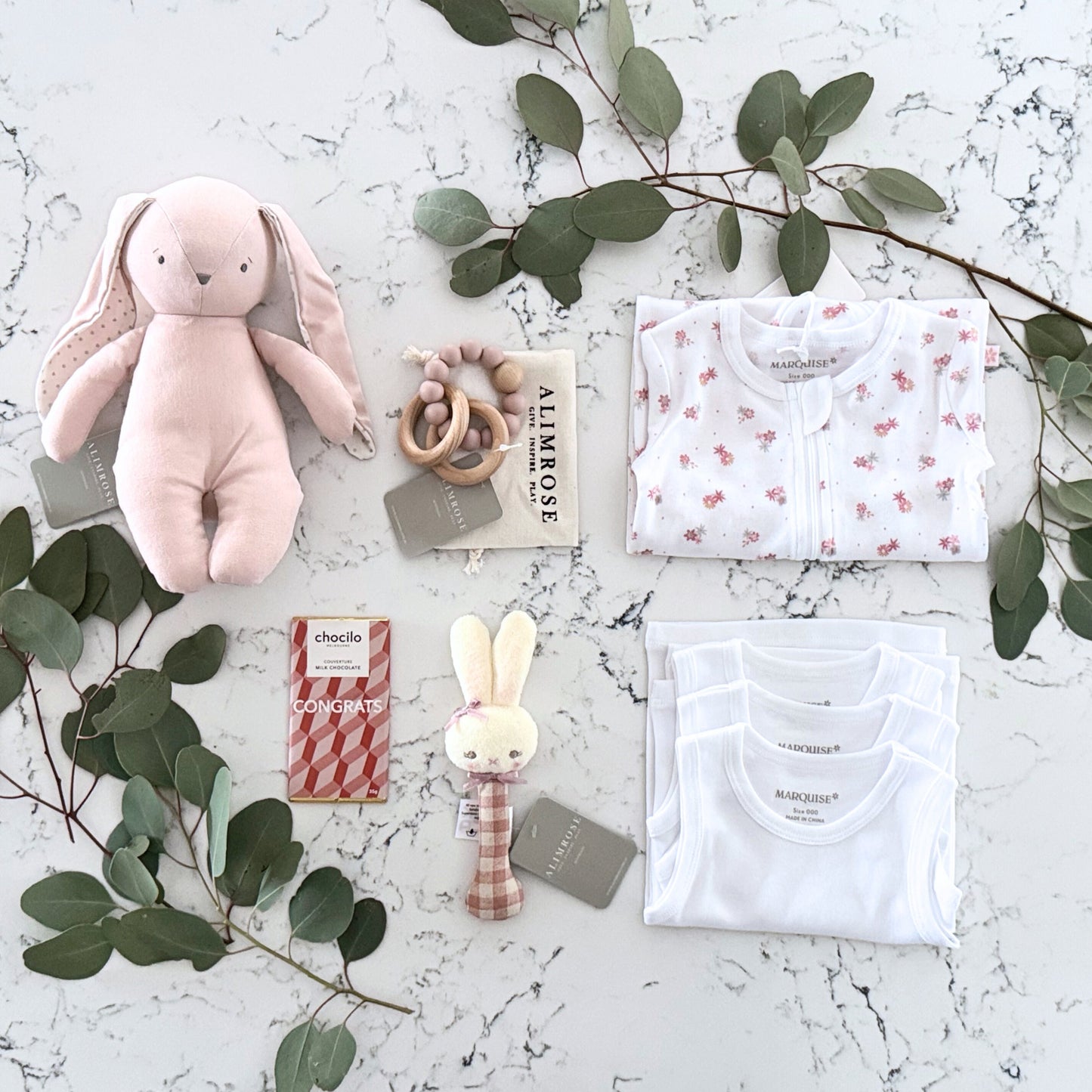Omoiyari Hello Baby Girl Gift hamper box -  blue bunny plush toy, chocolate, Marquise growsuit, rattle and a teething ring with green gum leaves.