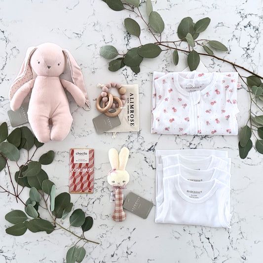 Omoiyari Hello Baby Girl Gift hamper box -  blue bunny plush toy, chocolate, Marquise growsuit, rattle and a teething ring with green gum leaves.