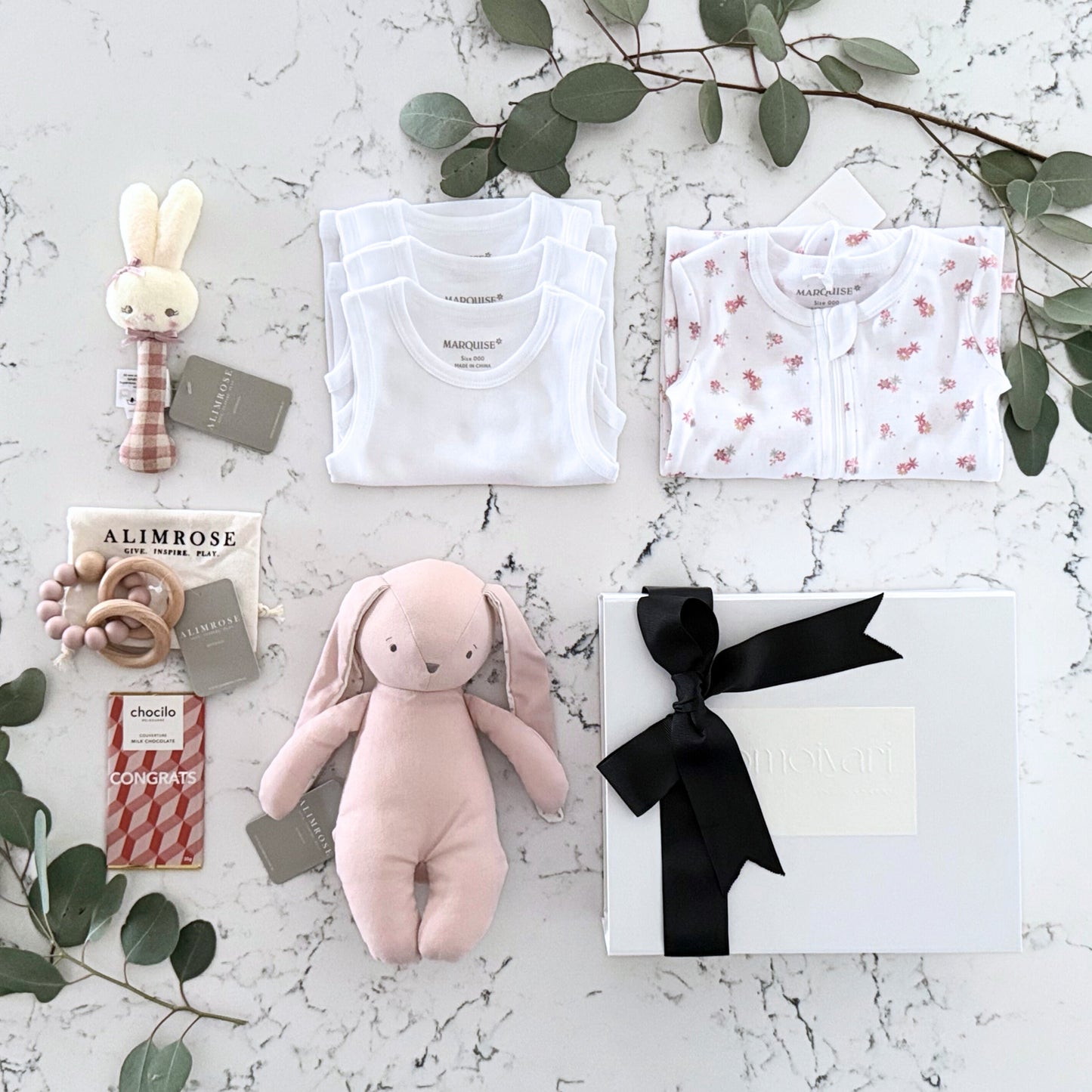 Omoiyari Hello Baby Girl Gift hamper box -  blue bunny plush toy, chocolate, Marquise growsuit, rattle and a teething ring with green gum leaves.