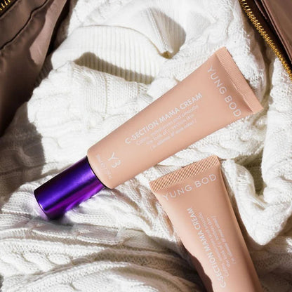 Two tubes of Yung Bod cream on a textured surface with a brown bag in the background.